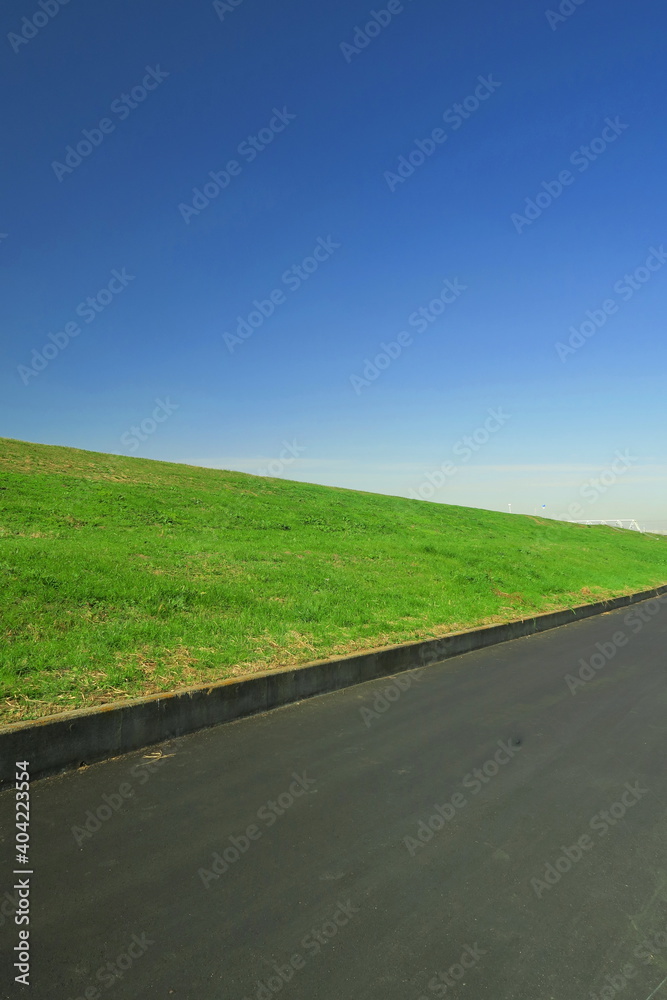 冬の新興住宅地の新しい道路と江戸川土手風景 冬の新興住宅地の新しい道路と江戸川土手風景