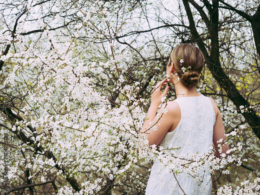 Cute, pretty woman on the background of flowering trees. Concept of rest and relaxation Cute, pretty woman on the background of flowering trees. Concept of rest and relaxation