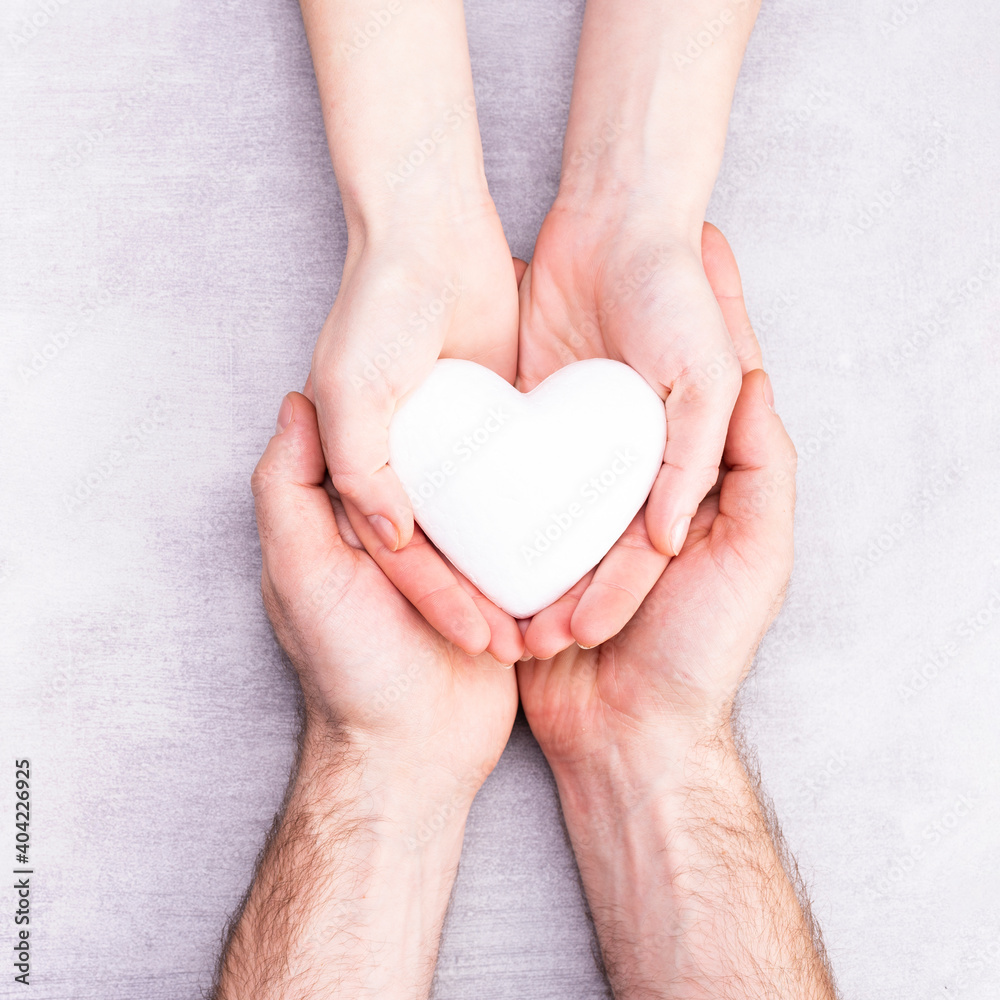 male and female hands with a white heart, health care, love and family insurance concept, world heart day, world health day, foster family, international family day male and female hands with a white heart, health care, love and family insurance concept, world heart day, world health day, foster family, international family day