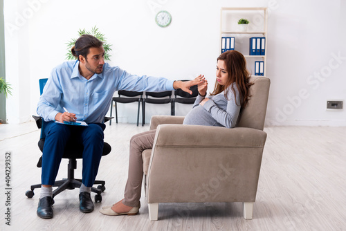 Pregnant woman visiting young male psychologist