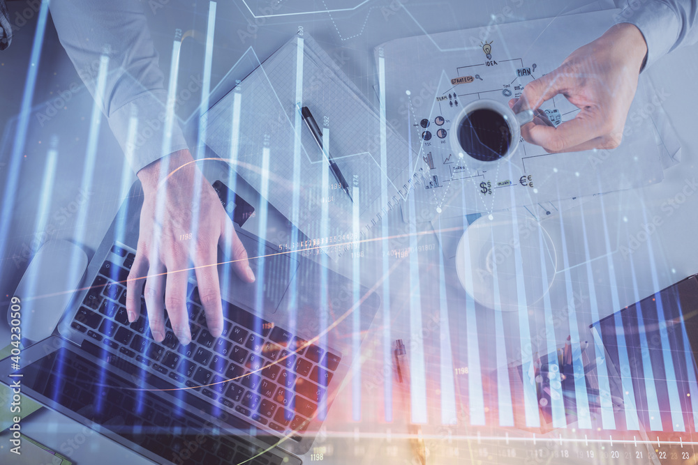 Multi exposure of man's hands typing over computer keyboard and forex graph hologram drawing. Top view. Financial markets concept. Multi exposure of man's hands typing over computer keyboard and forex graph hologram drawing. Top view. Financial markets concept.
