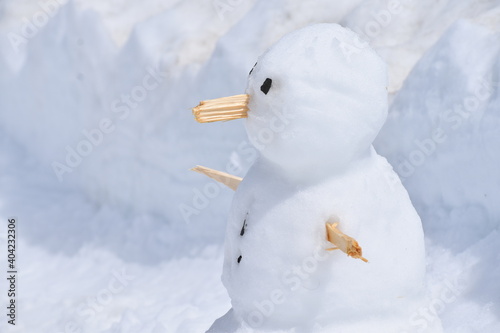 Closeup of a snowman in snow.