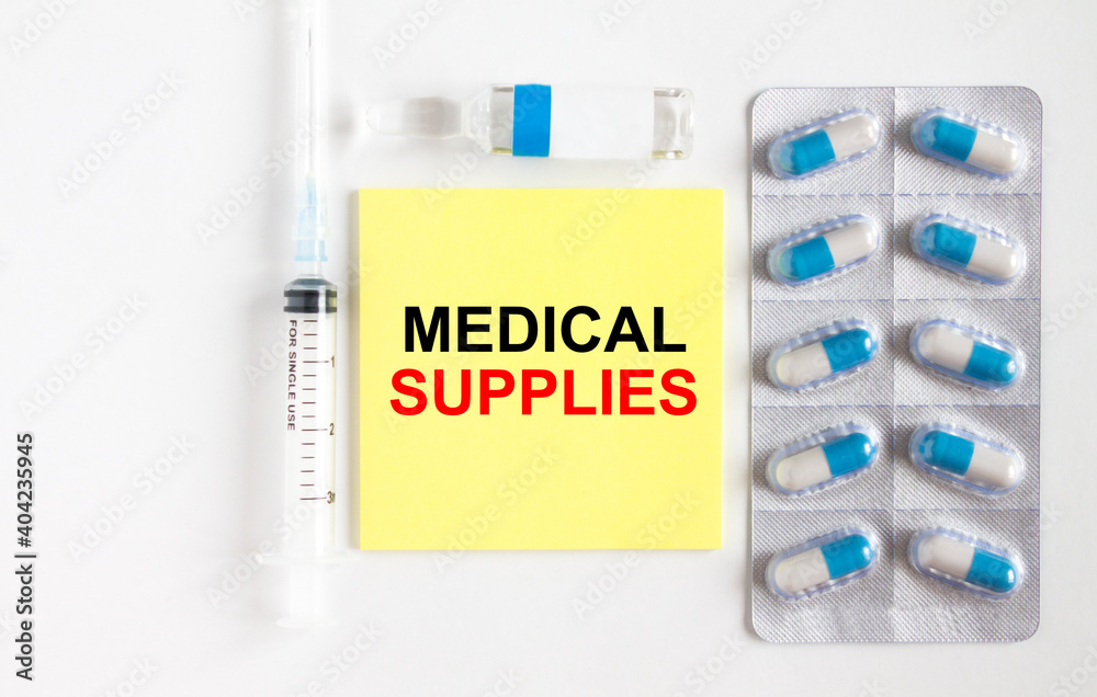 Yellow sticker with text Medical Supples on a white background with syringes, pills and ampoule.