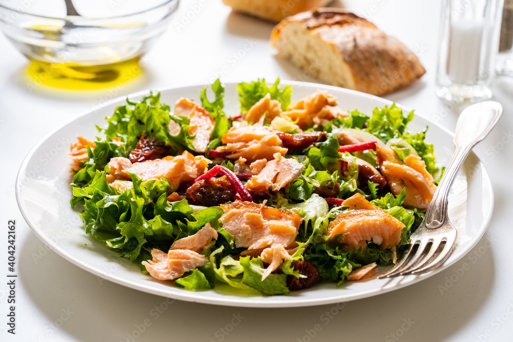 Salmon salad - roasted salmon with mix of vegetables on white background

