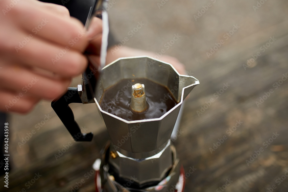 Traveler man making camping coffee outdoor with metal geyser coffee maker on a gas burner, step by step