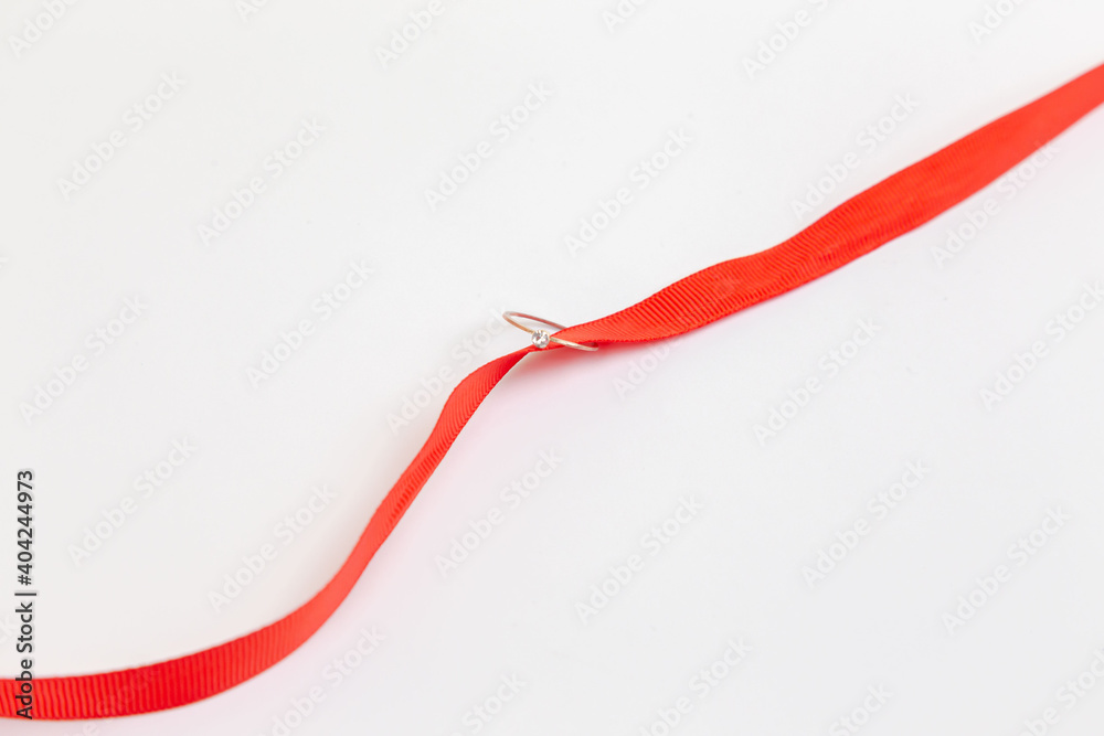 The wedding ring lies on a red ribbon. Place for an inscription. Wedding. Wedding ring. An offer of marriage. The wedding ring lies on a red ribbon. Place for an inscription. Wedding. Wedding ring. An offer of marriage.