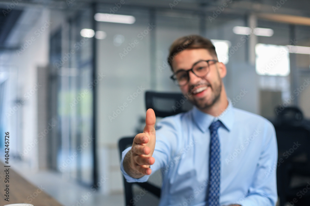Business man with an open hand ready to seal a deal in office. Business man with an open hand ready to seal a deal in office.