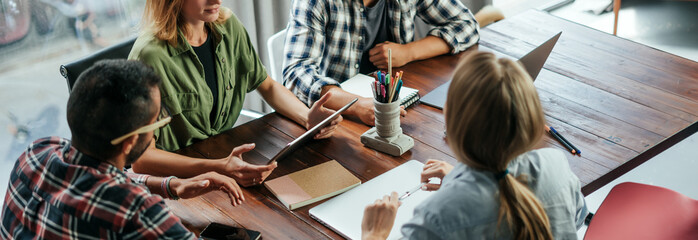 Group of young people working together. Creative business people in modern office. Hipster team in coworking. Young modern colleagues.