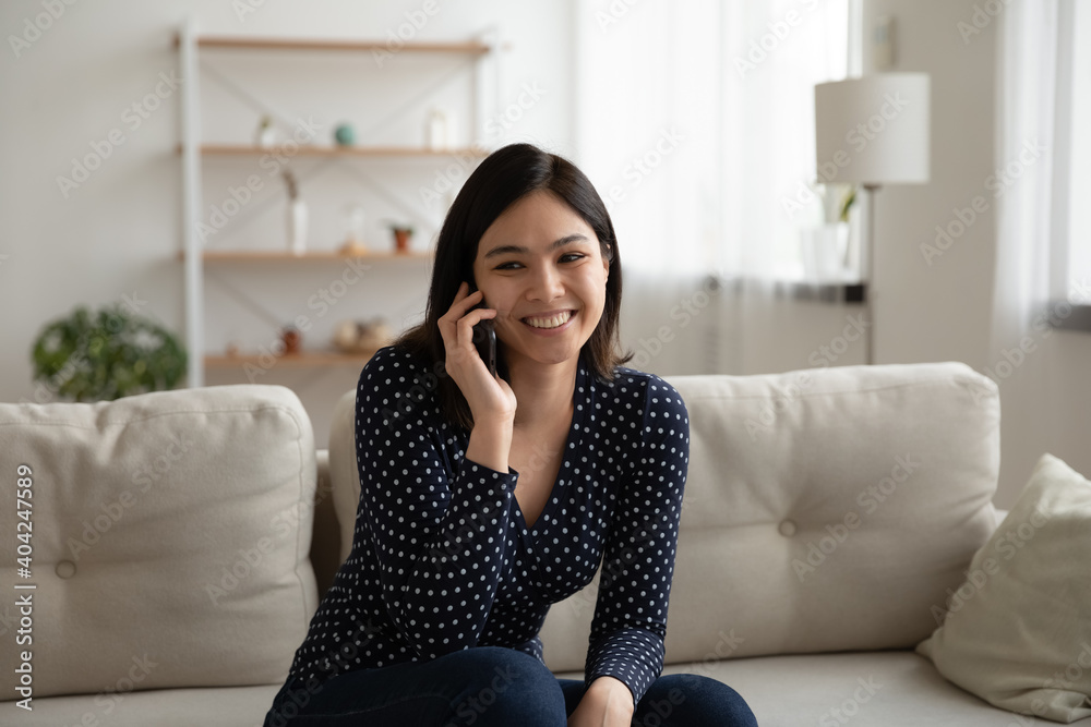 Happy beautiful asian korean mixed race woman involved in pleasant smartphone call conversation with friends sharing discussing life news, smiling female client calling operator ordering delivery food Happy beautiful asian korean mixed race woman involved in pleasant smartphone call conversation with friends sharing discussing life news, smiling female client calling operator ordering delivery food