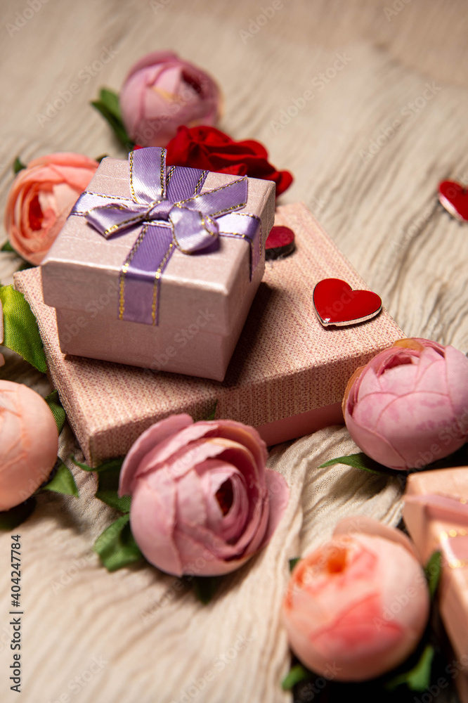 There are gift boxes next to the flowers on the table. Red heart symbol of love. Gifts for the holiday. Gifts for Valentine's Day. International Women's Day. Decoration. There are gift boxes next to the flowers on the table. Red heart symbol of love. Gifts for the holiday. Gifts for Valentine's Day. International Women's Day. Decoration.