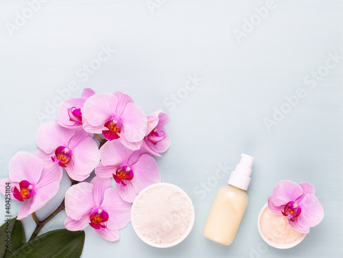 Sea salt, aromatherapy oil in bottles and orchid on vintage wooden background.