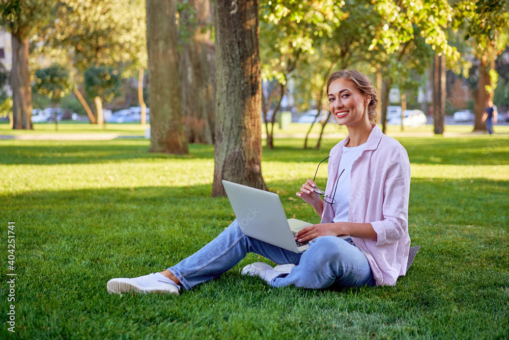 Businesswoman sitting grass summer park using laptop Business person working remote. Outdoor
