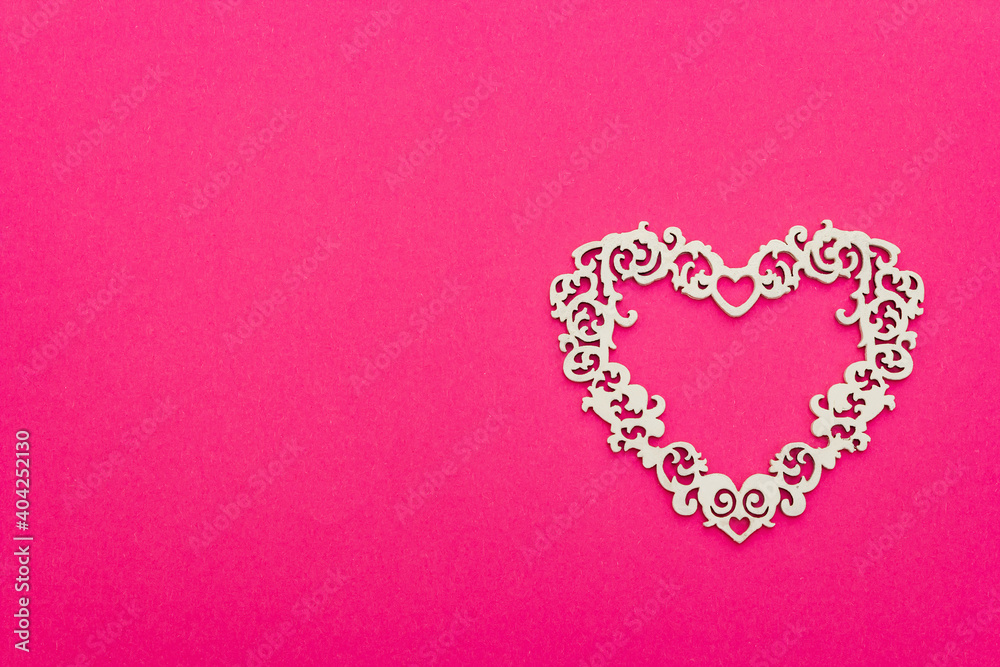 Festive composition with openwork white heart on pink background