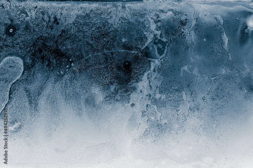 Ice texture background. Textured cold frosty surface of ice block on dark background.