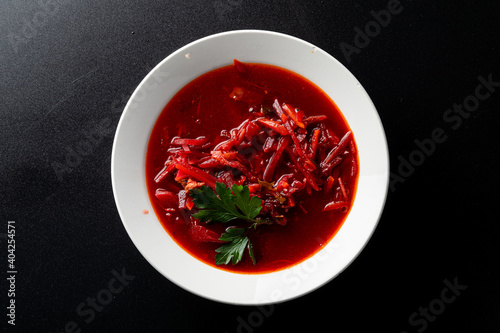 Traditional ukrainian beetroot soup borscht on a minimalistic black background, directly above