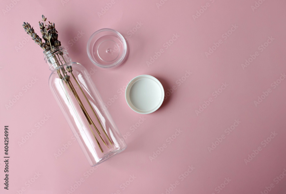 Plastic cosmetic bottle with lavender inside on a pink background Plastic cosmetic bottle with lavender inside on a pink background