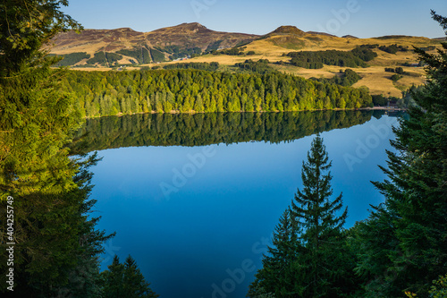 View of Lac Pavin in Auvergne (France), early in the morning. The Puy de Sancy volcano can be seen in the background