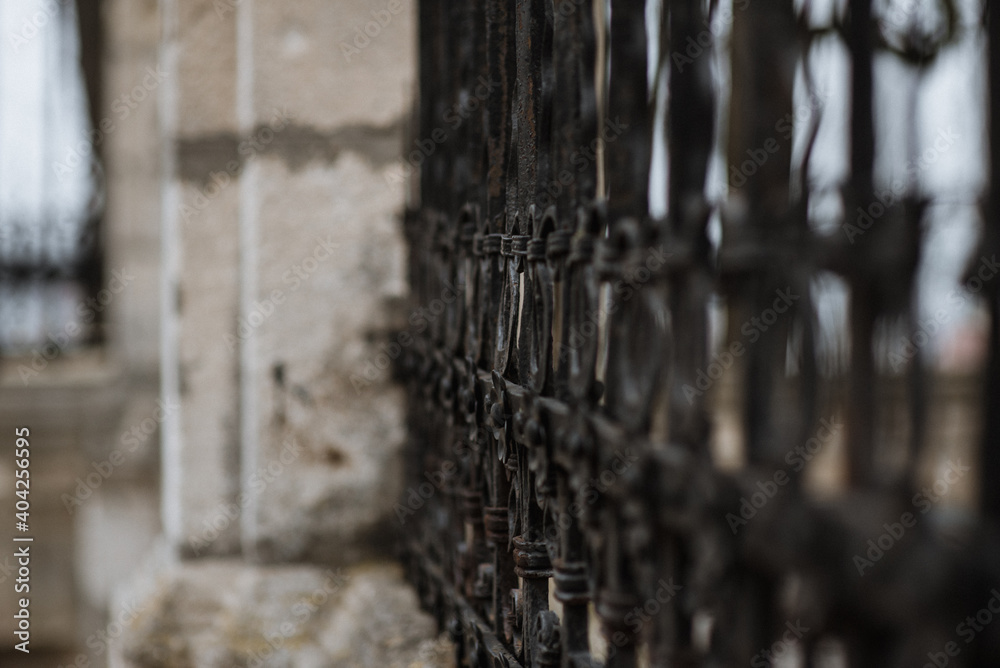 Black metal spiked residential fence diminishing to soft focus in the distance. background Black metal spiked residential fence diminishing to soft focus in the distance. background