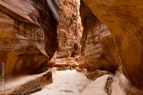 (Selective focus) Stunning view of a person in the distance walking on the path leading to Al Khazneh (The Treasury). Petra is a historical and archaeological city in southern Jordan.