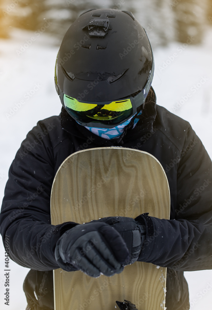 Young girl snowboarder putting up her gloves
