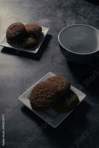 High Contrast of Cookies on White Plate with Empty Tea Cup
