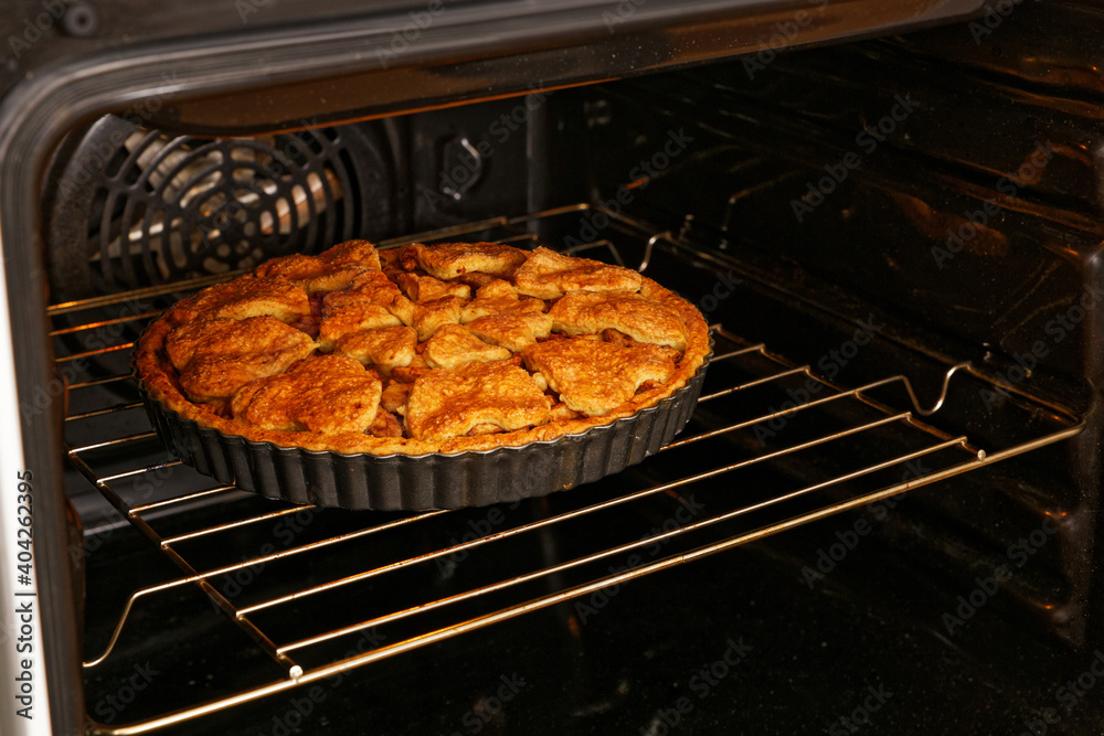 Homemade pie with apple, walnut and cinnamon cooked in the domestic oven. Shallow focus. Homemade pie with apple, walnut and cinnamon cooked in the domestic oven. Shallow focus.