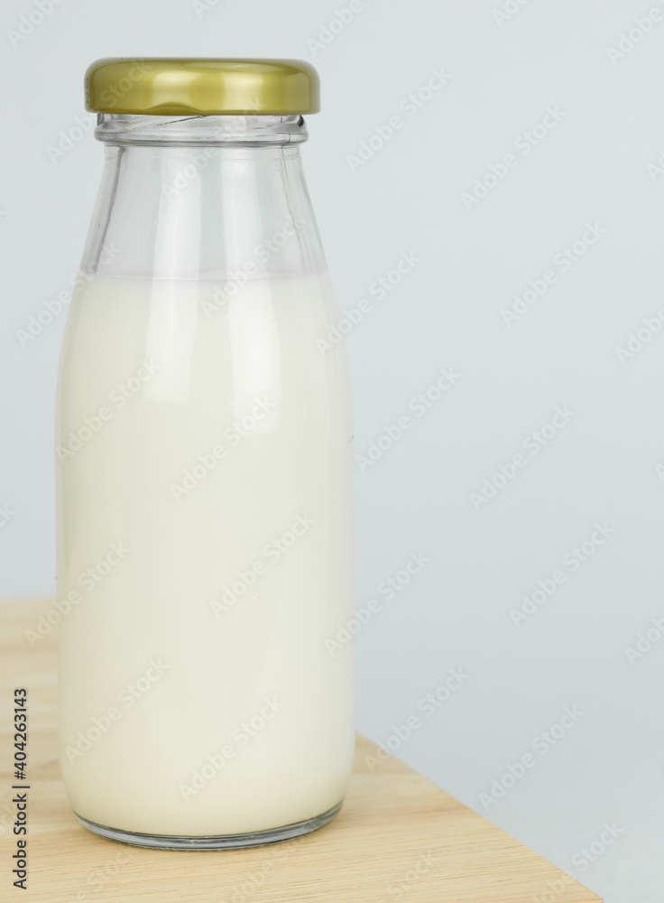 Bottles with fresh milk on a wooden table..Raw milk is high in calcium and protein to drink for all ages..Milk consumption nutritious and healthy dairy products concept. Bottles with fresh milk on a wooden table..Raw milk is high in calcium and protein to drink for all ages..Milk consumption nutritious and healthy dairy products concept.