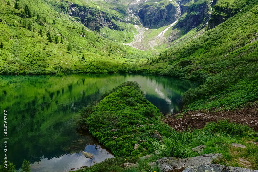 mountain lake between green mountain while hiking