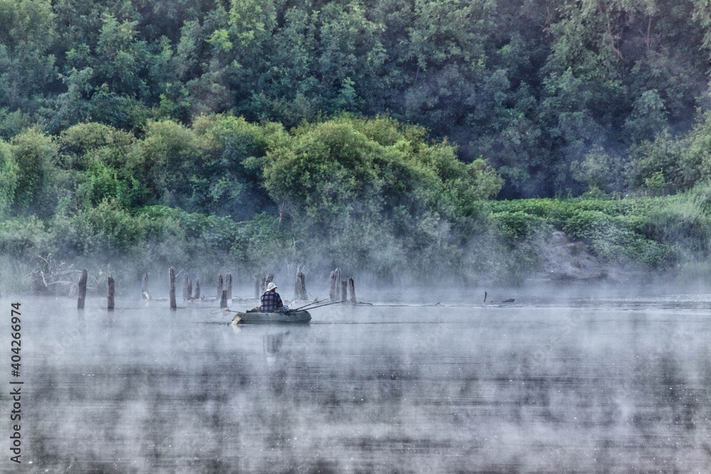 fisher in fog morning on the river