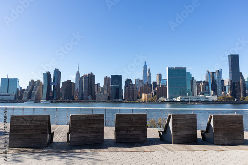 Empty Lounge Chairs along the Riverfront of Long Island City Queens New York with the Midtown Manhattan Skyline