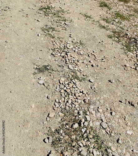 Dry stony dusty ground. Rustic road texture background.