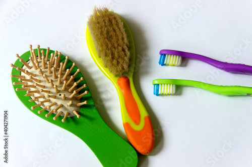 Personal hygiene. Toothbrushes and hairbrushes on a white background. View from above.