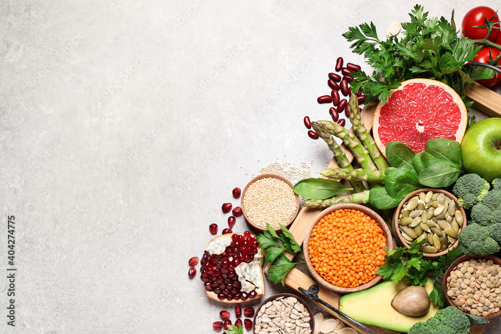 Fresh vegetables, fruits and seeds on grey table, flat lay. Space for text Fresh vegetables, fruits and seeds on grey table, flat lay. Space for text