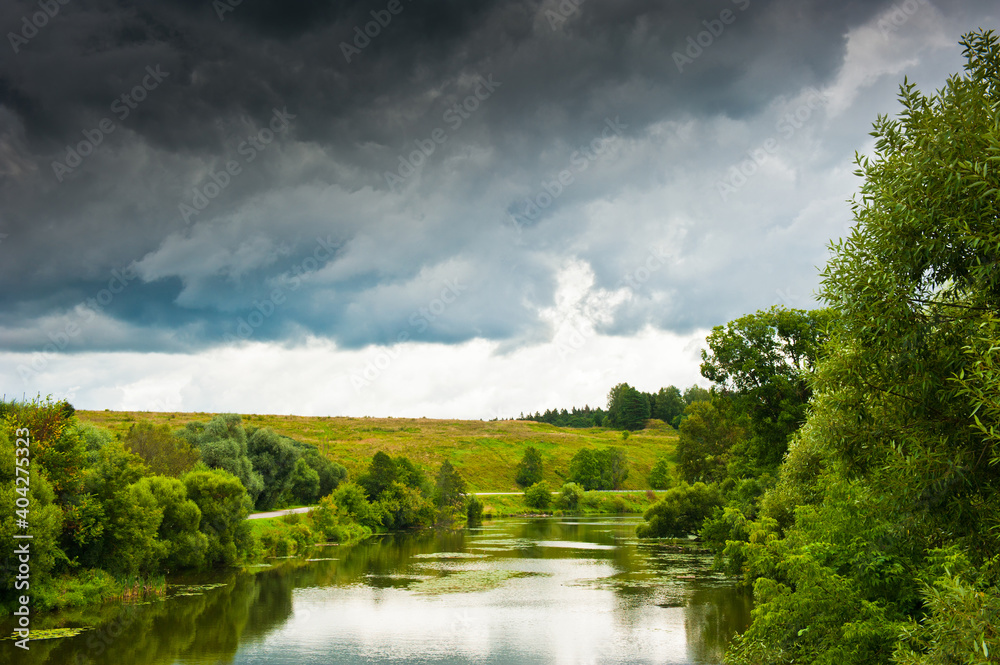 Forest, river and large black clouds before the rain. summer day Forest, river and large black clouds before the rain. summer day