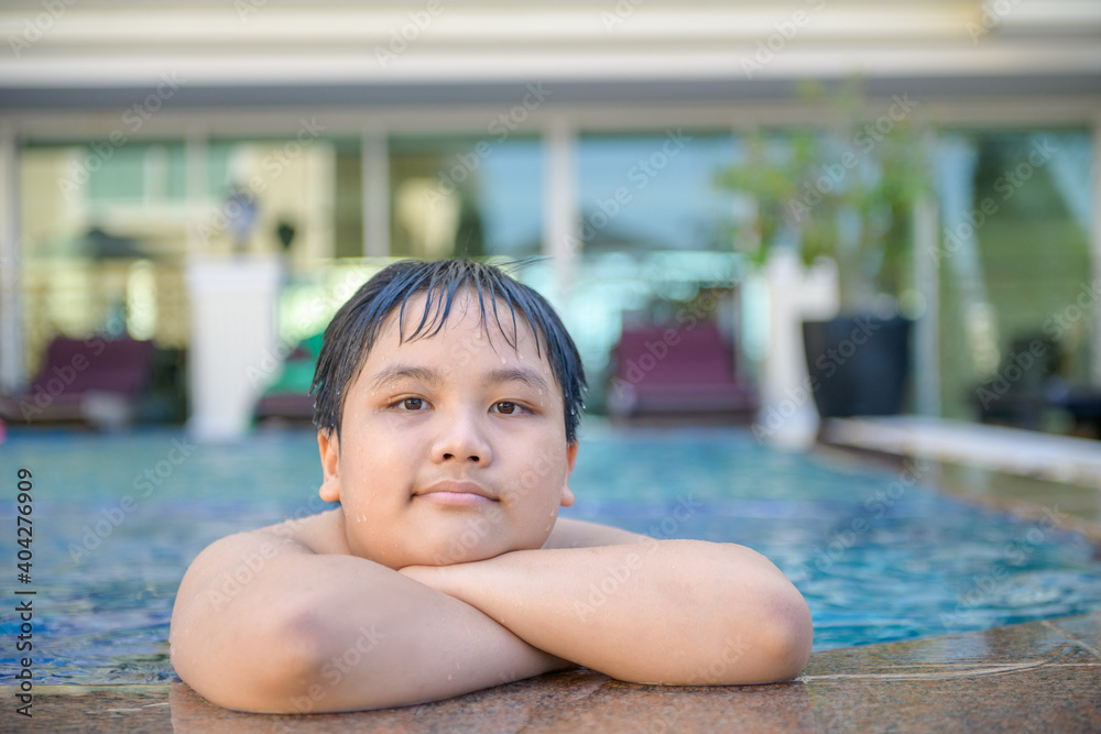 Happy fat boy in swimming pool, relax and exercise