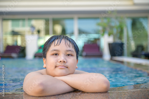 Happy fat boy in swimming pool, relax and exercise
