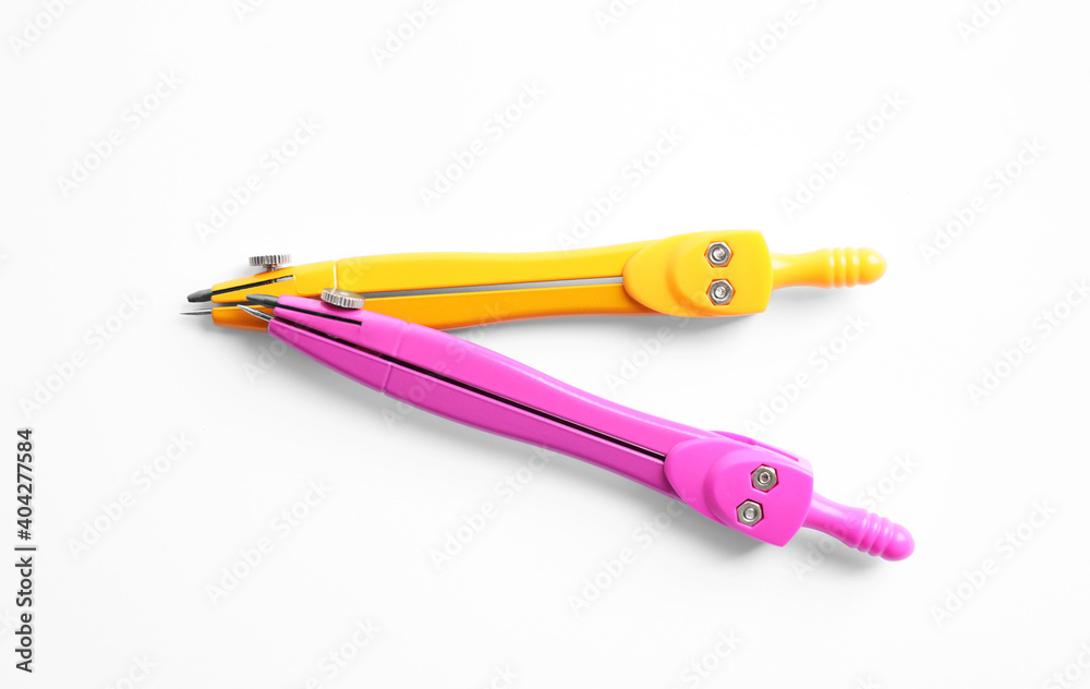 Colorful compasses on white background, top view. School stationery Colorful compasses on white background, top view. School stationery