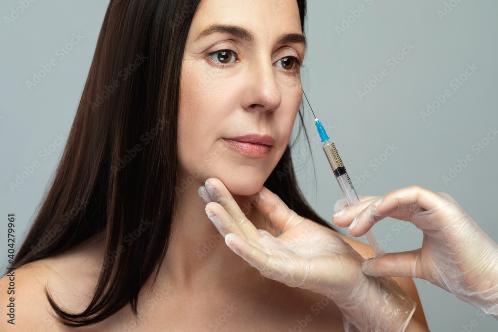 Middle aged woman receiving facial injection for skin rejuvenation Middle aged woman receiving facial injection for skin rejuvenation