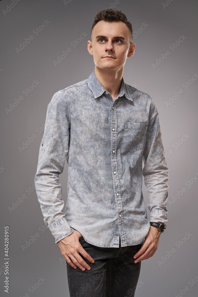 Fototapeta premium Young businessman on gray background