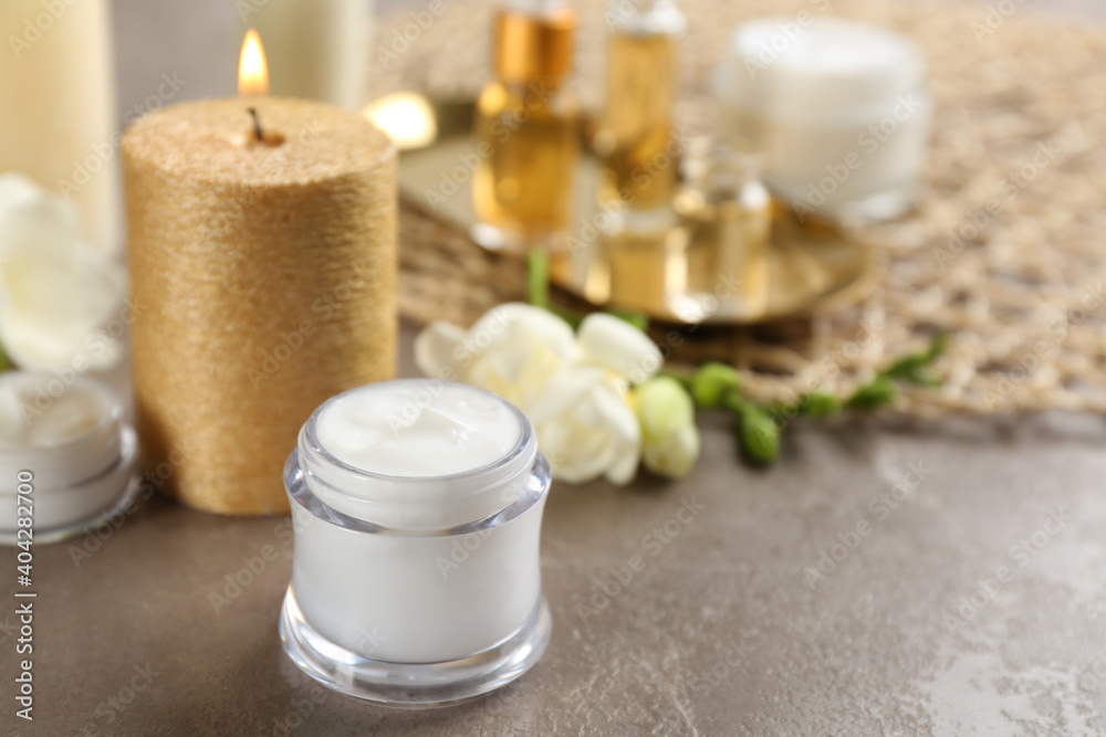 Beautiful spa composition with cosmetic products and candle on table. Space for text Beautiful spa composition with cosmetic products and candle on table. Space for text