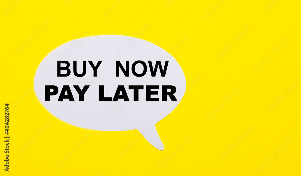 On a bright yellow background, white paper with the words BUY NOW – PAY LATER On a bright yellow background, white paper with the words BUY NOW – PAY LATER