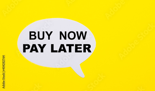 On a bright yellow background, white paper with the words BUY NOW – PAY LATER