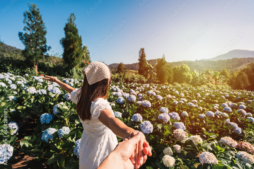 Young couple traveler relaxing and enjoying with blooming hydrangeas flower field in Thailand, Travel lifestyle concept - obrazy, fototapety, plakaty 