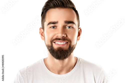Young and handsome bearded man wearing white t-shirt