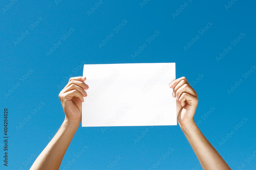 blank sheet of paper in hands on blue background blank sheet of paper in hands on blue background