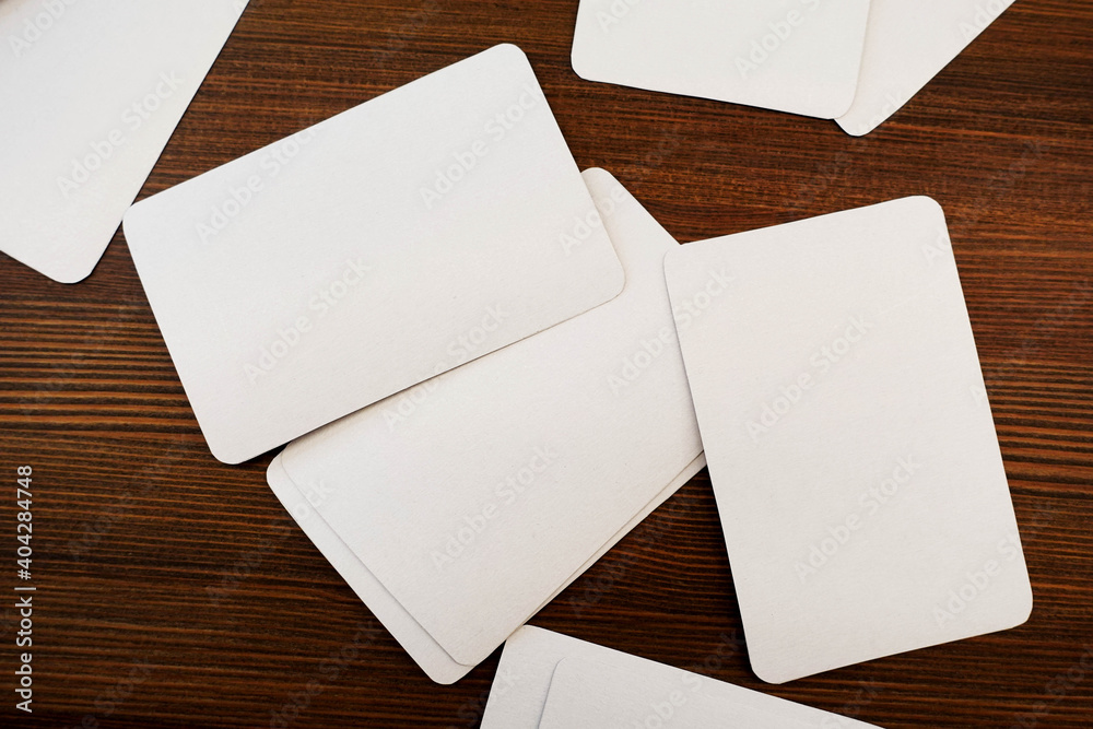 Mockup of a deck of playing cards. Blank white cards for design on wooden table Mockup of a deck of playing cards. Blank white cards for design on wooden table