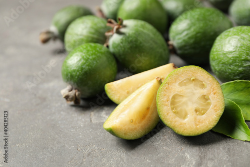 Fresh green feijoa fruits on grey table, closeup. Space for text