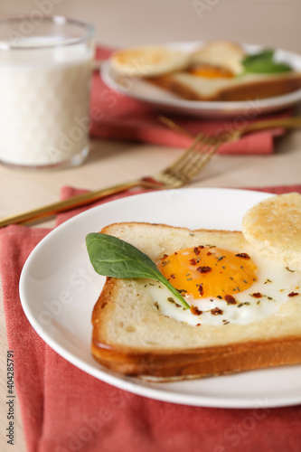 Tasty toast with fried egg and spinach leaf on table, closeup