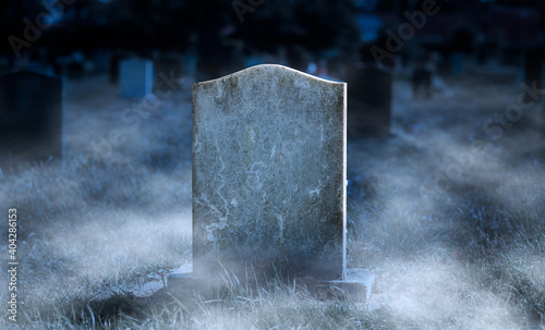 Valokuva Creepy blank gravestone in graveyard at night with low spooky fog