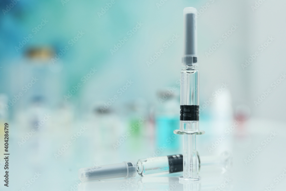 Syringes with COVID-19 vaccine on white table, space for text Syringes with COVID-19 vaccine on white table, space for text